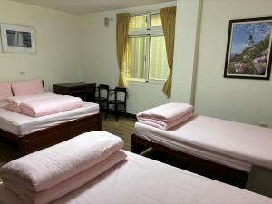 Zimmer mit 3 Betten und einem Fenster in der Unterkunft 今友緣二館民宿 in Dongyin/
