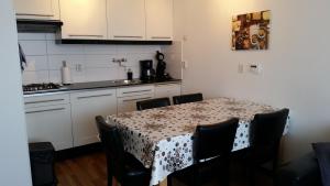 a kitchen with a table with chairs and a kitchen with white cabinets at PARKZICHT Bed by the Sea in Westkapelle