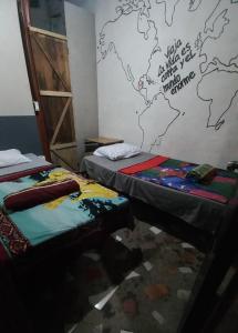 two beds in a room with a map on the wall at coraizone hostel in Cobán