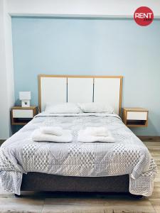 Una cama blanca con dos almohadas encima. en Rent River en Buenos Aires
