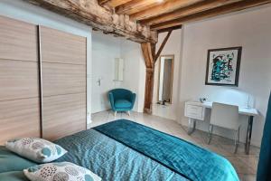 トロワにあるLe Scarabée Bleu - Confort Fonctionnel - Mon Groomのベッドルーム1室(ベッド1台、デスク、椅子付)