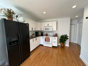a kitchen with white cabinets and a black refrigerator at The Little Retreat, Solo, Couples & Small Families in Sebring