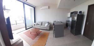 a living room with a couch and a refrigerator at TORRE FIRENZE EXTRAORDINARIO in Asuncion