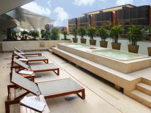 una fila de sillas y una piscina en un edificio en Hotel Estelar Milla De Oro, en Medellín