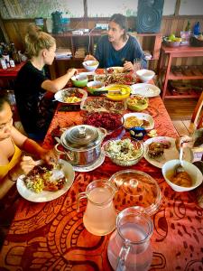 a group of people sitting around a table with food at Jungle Lodge with lookout tower in Pucallpa