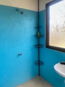 y baño con pared azul y toallero. en Casa Tortolita, en Mazunte