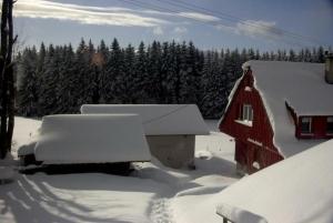 a barn covered in snow next to a house at Ferienhaus für 3 Personen 1 Kind ca 85 qm in Eisenbach, Schwarzwald Naturpark Südschwarzwald in Oberbränd