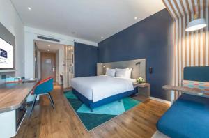 سرير أو أسرّة في غرفة في Holiday Inn Express Qingdao Chengyang Central by IHG