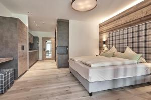 una camera da letto con un grande letto bianco e pavimenti in legno di Ferienwohnungen direkt an der Skiabfahrt und MTB-Trails - b56870 a Sölden