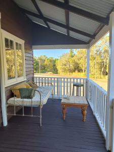 a porch with a couch and a coffee table at Timbermiller's cottage in Deeside