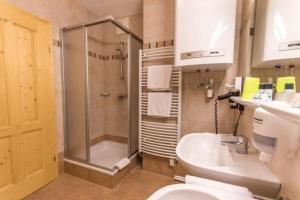 a bathroom with a shower and a toilet and a sink at Wohnung in Sankt Oswald mit Terrasse, Grill und Garten in Bad Kleinkirchheim