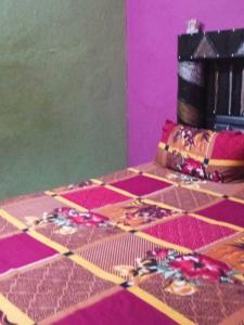 een kamer met een tafel met roze en paars bij POP Pinki Homestay in Arli