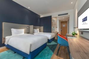 سرير أو أسرّة في غرفة في Holiday Inn Express Qingdao Chengyang Central by IHG