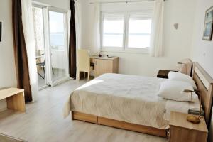 1 dormitorio con 1 cama, escritorio y ventanas en Ferienhaus am Meer - kostenloses Aufladen von Elektrofahrzeugen, en Rtina