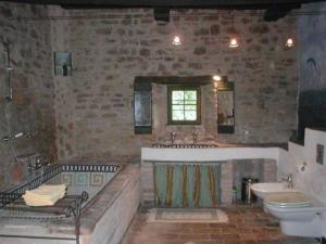 un gran baño de piedra con bañera y lavabo. en Ferienhaus für 4 Personen 1 Kind ca 80 qm in Piandimeleto, Marken Provinz Pesaro-Urbino en Piandimeleto
