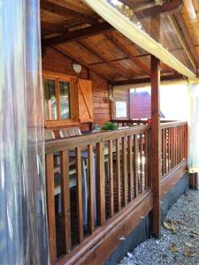 a porch of a cabin with a wooden railing at Ferienhaus in Porlezza mit Terrasse und gemeinsamem Pool in Porlezza