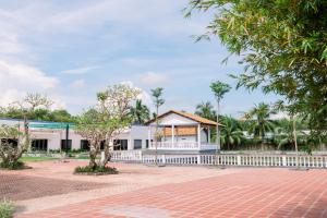 a white building with a white fence and trees at NGOC THU HOTEL in Soc Trang