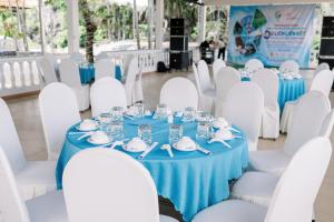 una mesa para una boda con mantel azul y sillas blancas en NGOC THU HOTEL, en Soc Trang