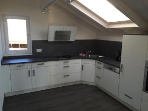 a kitchen with white cabinets and a window at Tolle Wohnung in Ofterschwang mit Eigener Sauna und Bergblick in Ofterschwang