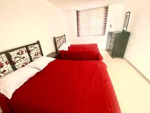 ein Schlafzimmer mit einem roten Bett mit einer roten Decke in der Unterkunft Casa de descanso con piscina Galileos in León