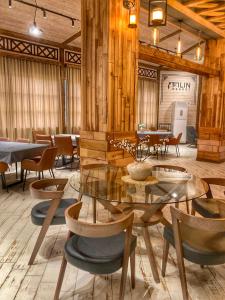 jadalnia z drewnianymi ścianami, stołami i krzesłami w obiekcie Filin Resort w mieście Iczewan