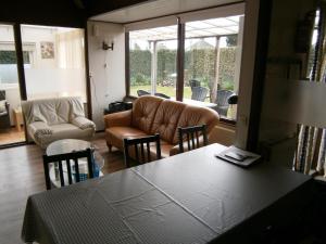 uma sala de estar com um sofá, uma mesa e cadeiras em Doppelhaushälfte für sechs Personen in einem Ferienpark in der Nähe von Stavenisse direkt hinter dem Deich em Stavenisse