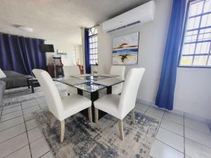 a dining room with a glass table and white chairs at Cozy Corner w/private pool in Vega Baja