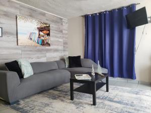 ein Wohnzimmer mit einem Sofa und einem blauen Vorhang in der Unterkunft Cozy Corner w/private pool in Vega Baja
