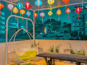 a hammock and a table on a balcony with lanterns at Saigon Hotel & Apartment in Ho Chi Minh City