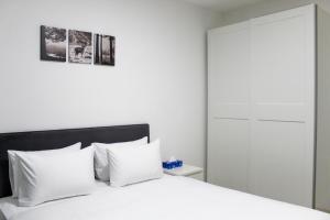 1 dormitorio con cama blanca y almohadas blancas en Suite Apartment #21 By Hashdera Eilat, en Eilat