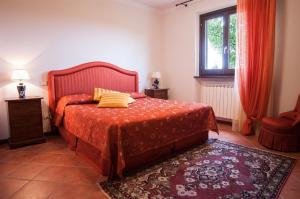 1 dormitorio con 1 cama con colcha roja y ventana en Großes Ferienhaus in Lonnano mit Schönem Garten, en Pratovecchio
