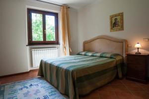 1 dormitorio con cama y ventana en Großes Ferienhaus in Lonnano mit Schönem Garten, en Pratovecchio