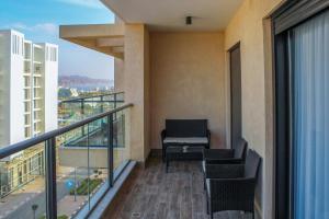 - Balcón con sillas y mesa en un edificio en Suite Apartment #21 By Hashdera Eilat, en Eilat