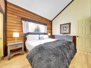 - une chambre avec un grand lit et un mur en bois dans l'établissement Snowshoe Village 5a Ski In-out, à Brian Head