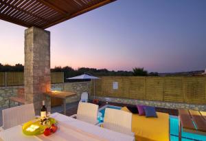 a patio with a table and chairs and a pool at Villa Alexandra - Komfort mit eigenem Pool in Loutra