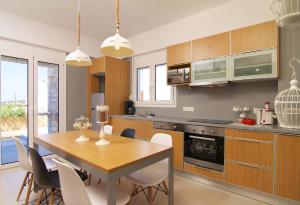 a kitchen with a wooden table and a dining room at Villa Alexandra - Komfort mit eigenem Pool in Loutra