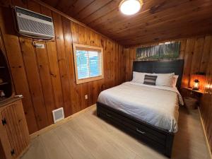 a bedroom with a bed in a wooden cabin at Rustic 1 bd 1 ba Cabin at New Waitts Lake Resort in Valley