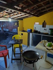a kitchen with a table and chairs in a room at Casa do Edi in Bananeiras