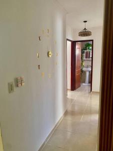 a hallway with a clock on a white wall at Acogedor apartamento amueblado in Los Paredones