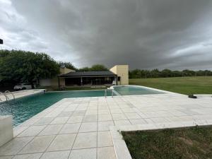 a swimming pool in front of a house at Finca la ponderoza in Santiago del Estero