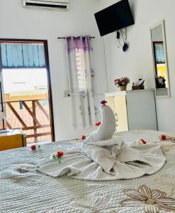 ein weißer Schwan auf einem Bett in der Unterkunft Pousada Cafe e Mar Jeri in Jericoacoara