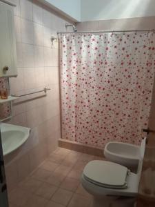 a bathroom with a shower curtain with red flowers at Duplex Céntrico in Mendoza +26 photos
