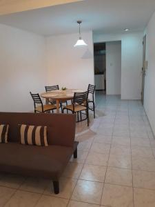 sala de estar con sofá, mesa y sillas en Duplex Céntrico en Mendoza