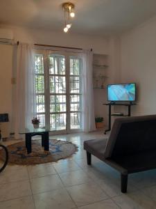 sala de estar con sofá y TV en Duplex Céntrico en Mendoza