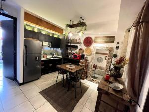 cocina con mesa y nevera de acero inoxidable en Bonito apartamento en zona 1 Ciudad de Guatemala, en Guatemala
