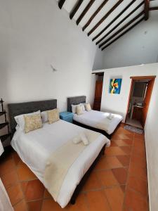 twee bedden in een kamer met witte muren bij Apartamento de la Villa I in Villa de Leyva