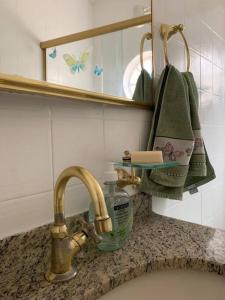 a bathroom sink with a faucet and a bottle of soap at Apartamento central em João Monlevade in João Monlevade