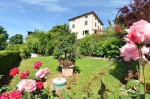 een tuin met bloemen en een huis op de achtergrond bij Ferienhaus mit Privatpool für 6 Personen ca 80 qm in Ciciana, Toskana Provinz Lucca in Ciciana