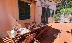 een houten tafel en stoelen op een patio bij Ferienhaus mit Privatpool für 6 Personen ca 80 qm in Ciciana, Toskana Provinz Lucca in Ciciana