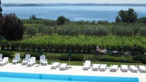 un grupo de sillas y una mesa con vistas al océano en Appartement in Moniga Del Garda mit Grill, Garten und gemeinsamem Pool und Seeblick, en Moniga del Garda